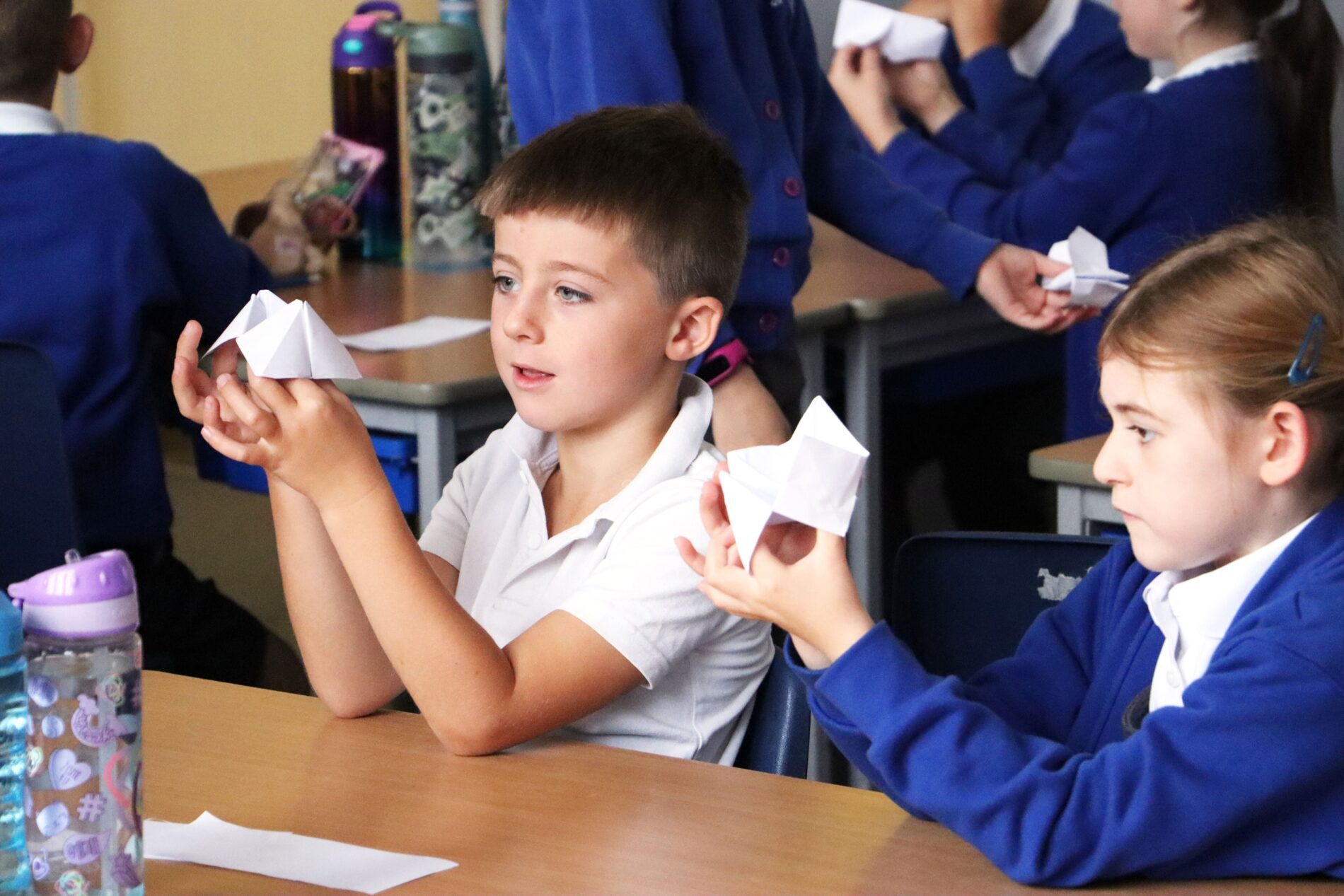 two pupils playing with chatterboxes, folded up origami