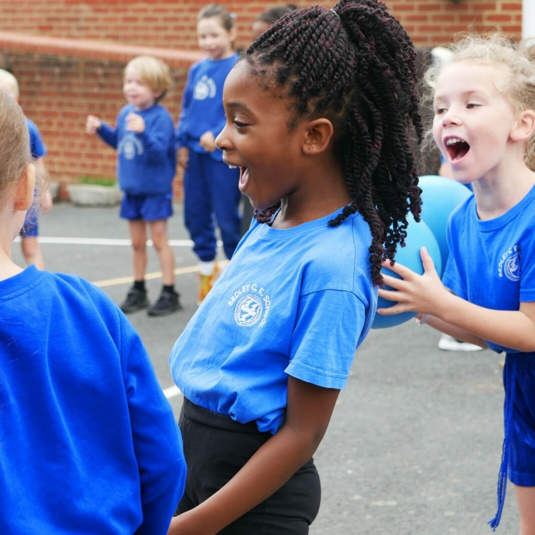 children laughing ouside on the playground during a PE lesson
