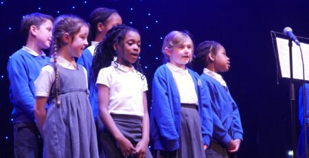 Sedleys primary school choir standing on stage at the Aletheia Academies Trust choir concert