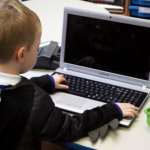 IMG_0227 EYFS pupil looking at a laptop