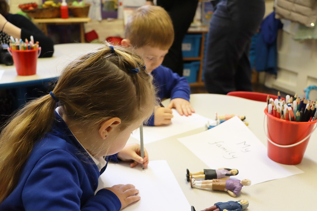 two EYFS pupils drawing their family