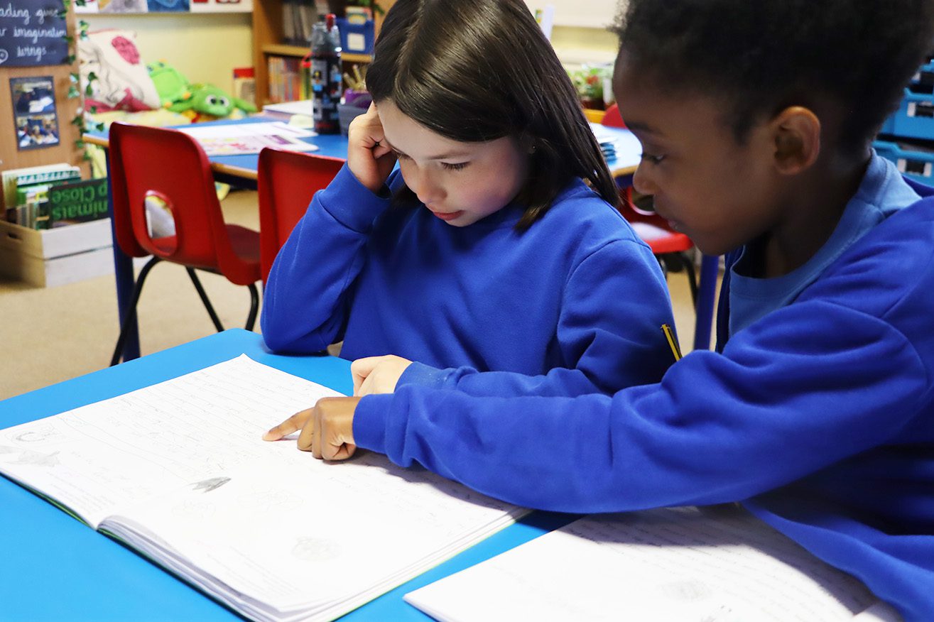 IMG_3137 one pupil pointing at and reading another pupils work at sedleys primary school