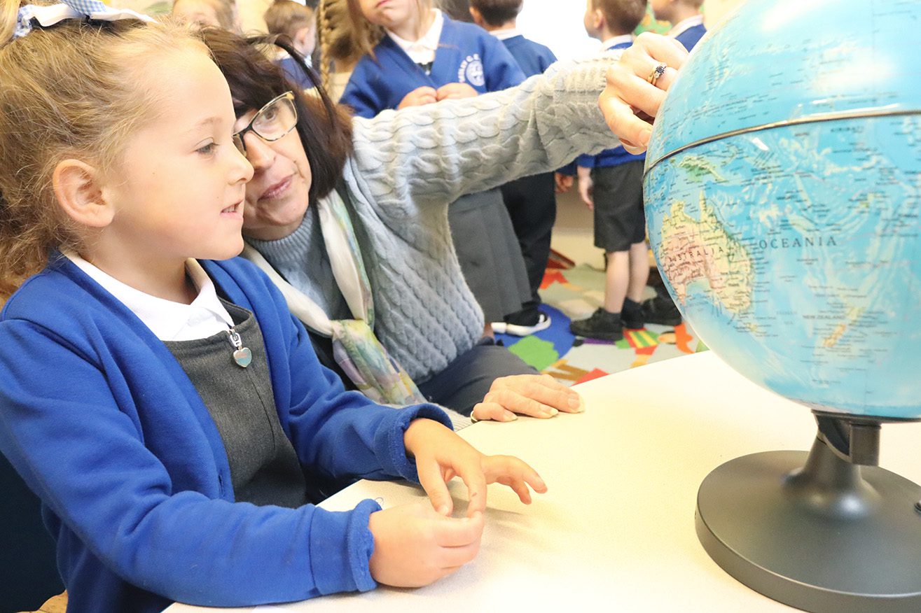 IMG_8435 EYFS pupil looking at globe with teacher