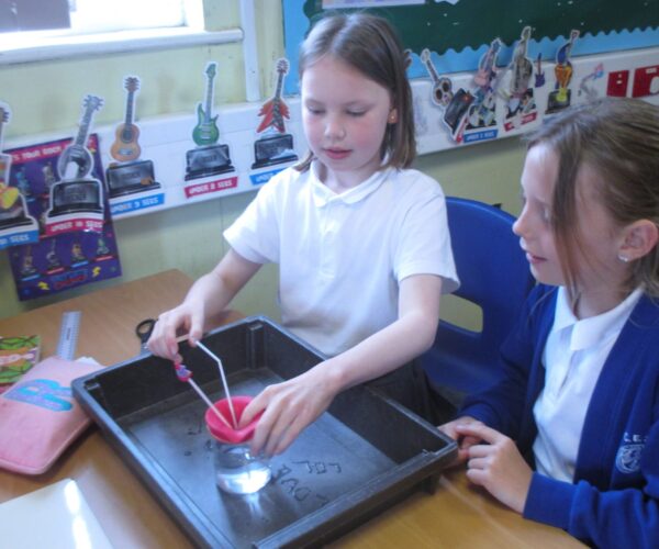 two pupils from sedleys showing the set up of their science experiment
